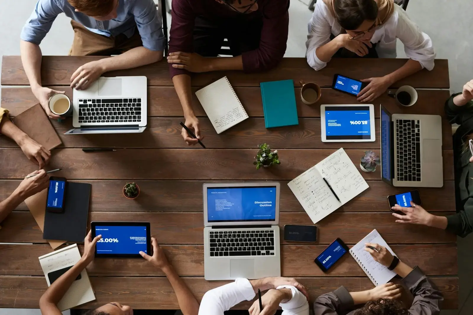 Team working together around a table with laptops and devices